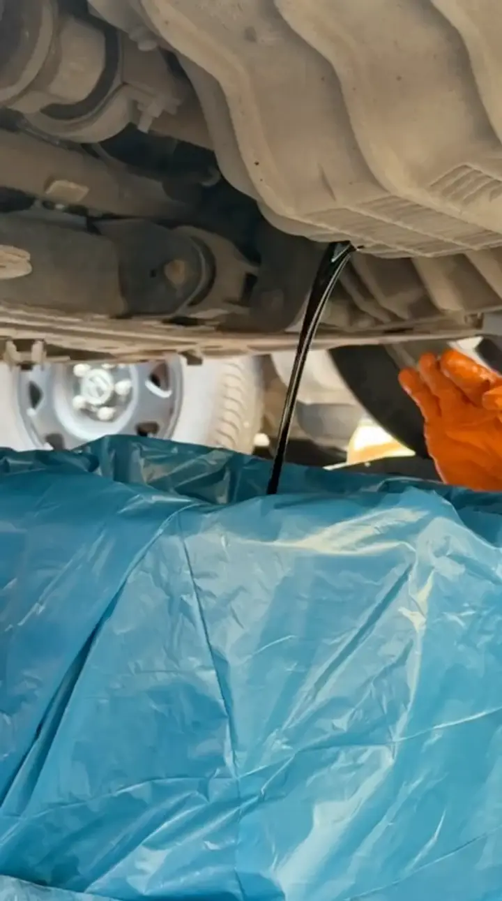 An oil change up close — draining the old oil into a clean container